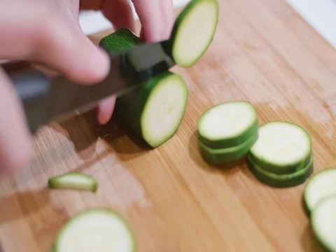 Cutting a cucumber on a cutting board Stock Footage