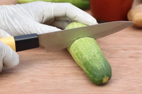 Cutting cucumber with a kitchen knife Stock Photos