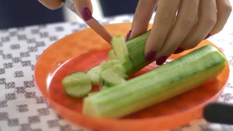 Cutting cucumber on plastic plate Stock Footage 142190507