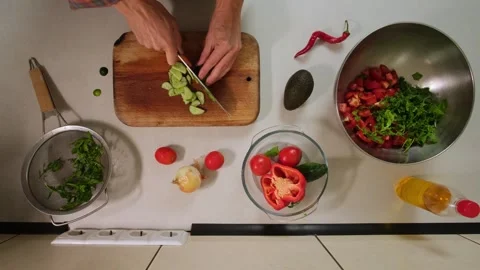 Cutting cucumber for salad in timelapse top view Video stock 316408689