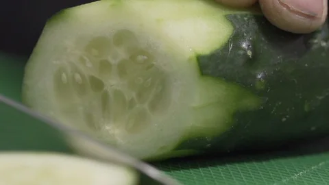 Cutting Cucumber witha a knife in the kitchen Macro Stock Footage 128826244