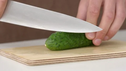 Cutting cucumbers into small slices on white background isolated Stock Footage 92293177