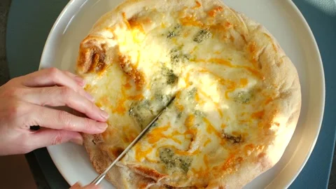 Cutting a delicious four cheese pizza with a knife Stock-Footage 337548711