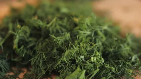 Cutting dill, chef cut dill with knife on a wooden board, close up at home. Stock Footage 238552924