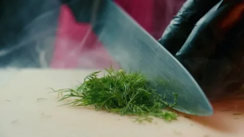 Cutting dill with a knife in the smoke. Video stock 137896410
