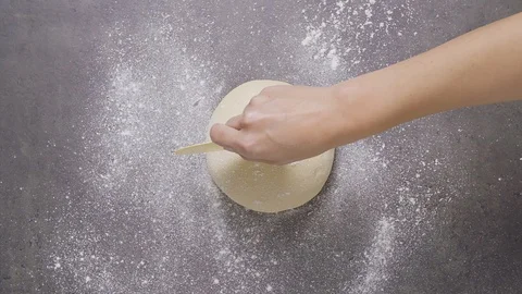 Cutting dough ball into quarters Stock Footage 124584936