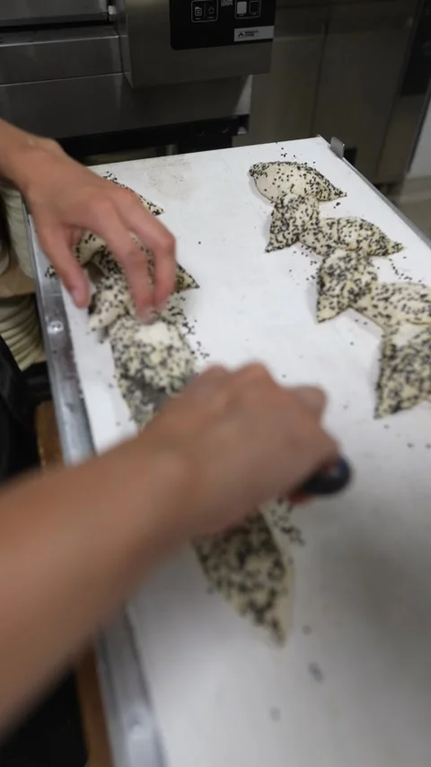 Cutting the dough to create a custom shape for the bread, the baker proceeds. 動画素材 246672017