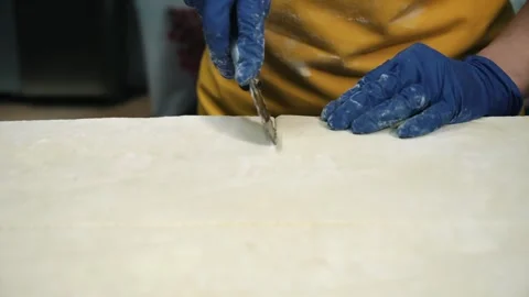Cutting the dough with a knife. The process of home baking from wheat flour. The Video stock 256108533