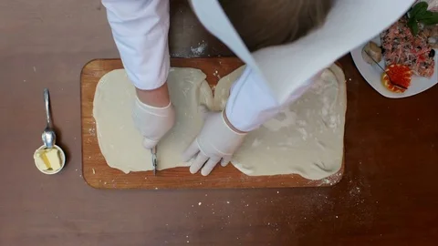 Cutting dough with roller knife for ravioli on table Stock Footage 74940800