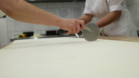 Cutting dough a round cutter knife. Media. Close-up of baking dough cut into Stock Footage 167579166