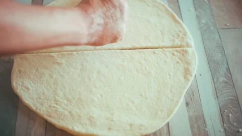 Cutting dough into triangles with pastry wheel close up, preparing homemade Stock Footage 337878182