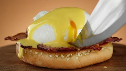 Cutting egg Benedict with runny egg yolk over toast Stock Footage 169440643
