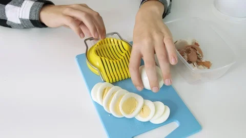 Cutting eggs of egg slicer on board close-up Stock Footage 102557634