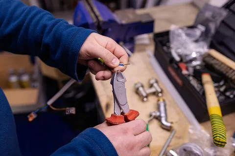 Cutting Electrical Wires with Pliers on Workbench, Electrician Preparing Cable f 库存照片