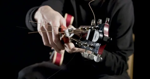 Cutting off the excess guitar strings Video stock 101604029