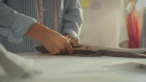 Cutting fabric for garment creation in a bright sewing studio during the aft Stock Footage 291435616