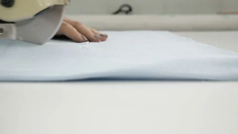 Cutting the fabric, sewing work. Cutting room, woman hands cutting blue cloth Stock Footage 100243500