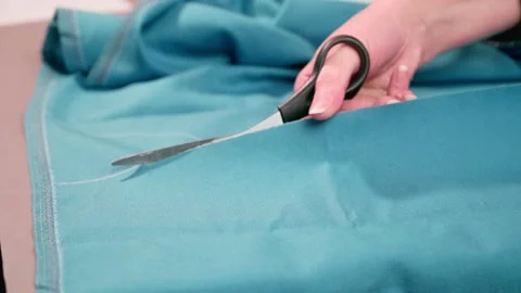 Cutting the fabric with sharp scissors. Cut the fabric with tailor's scissors Stock Footage 148174287