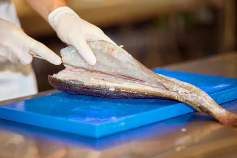 Cutting fish by the chef. Hands and fish close up Стоковые фото
