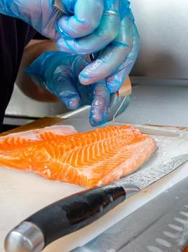 Cutting the fish on the kitchen board. Stock Photos