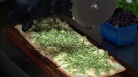 Cutting Flatbread with Green Sauce Stock Footage 319950980