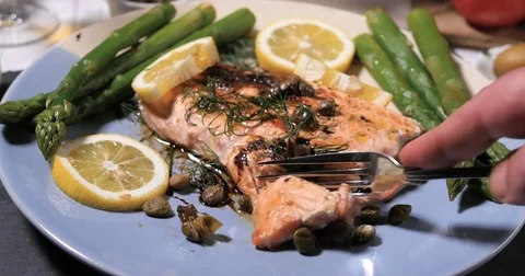 Cutting with a fork a delicious roasted organic salmon with capers and dill Stock Footage 72952216