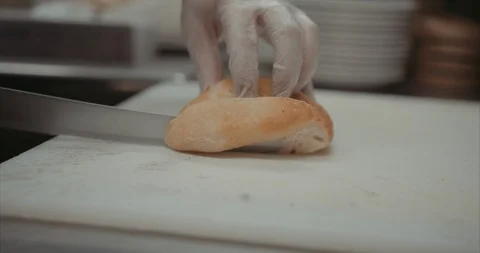 Cutting up up fresh bread in the back of a kitchen Video stock 105310870