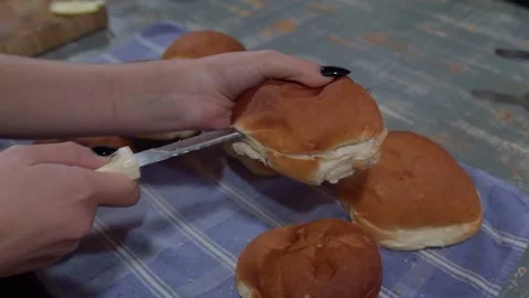 Cutting Fresh Bread Roll with Knife in Kitchen Stock Footage 321207778