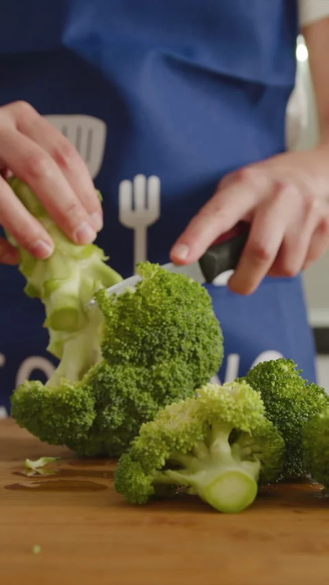 Cutting fresh broccoli for a delightful kitchen meal Stock Footage 341763333