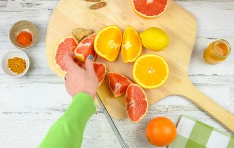 Cutting fresh citrus fruit to make homemade juice Stock Photos