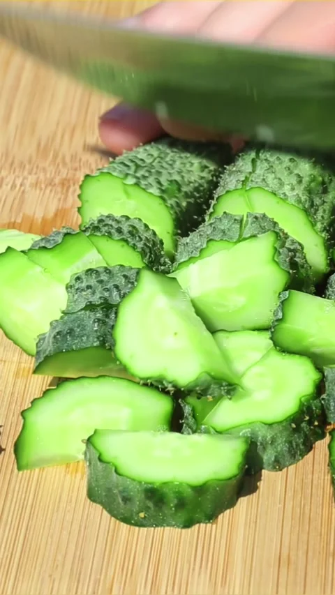 Cutting fresh cucumber into slices with sharp kitchen knife Video stock 317162152