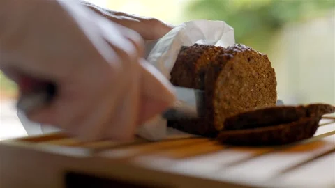 Cutting fresh dark baked bread with bread knife Видео 285319929