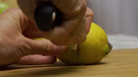 Cutting fresh lemon in half with large knife on chopping board - closeup shot Stock Footage 341186998