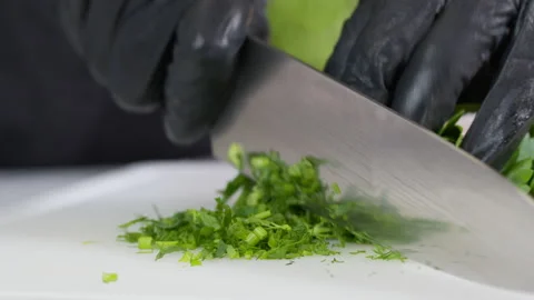 Cutting fresh sprigs of parsley on cutting board, slow motion. Stock Footage 144182889