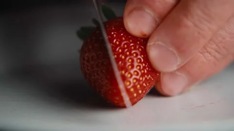 Cutting fresh strawberry in half close up Stock Footage 344692160