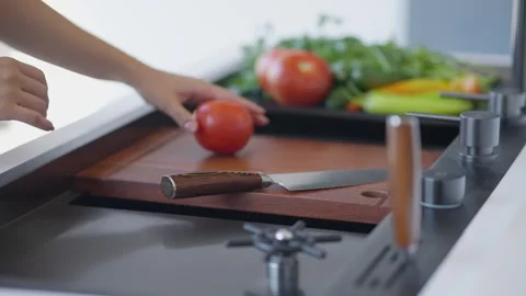Cutting fresh tomatoes on kitchen cutting board Stock Footage 336466150