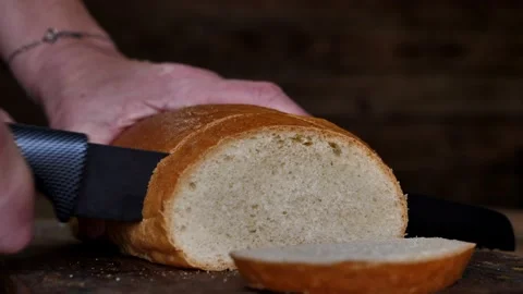 Cutting fresh wheat bread with a special knife. Preparing for breakfast or lunch Stock Footage 196791535