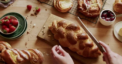 Cutting freshly baked bread on a breakfast table 4K. Table with healthy food. Stock Footage 221569527