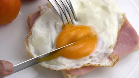 Cutting fried chicken egg on ham and toast in white ceramic plate. Stock Footage 196141924