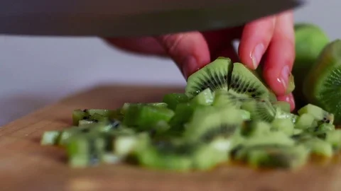 Cutting Fruit Close up With Knife - Kiwi Fruit, Woman Cuts Kiwi on wooden board Stock Footage 70965667