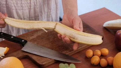 Cutting fruit on the kitchen table. Stock Footage 89122894