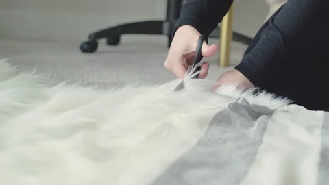 Cutting furry material with scissors on the floor in a crafting space Stock Footage 310305065