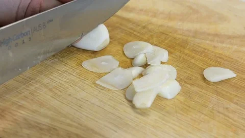 Cutting garlic on a cutting board with Stock Footage 78279432