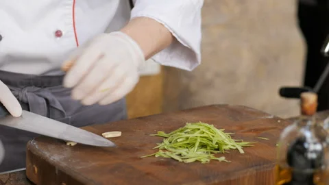 Cutting garlic with a sharp knife. The hands of the chef with a knife Stock Footage 150442461