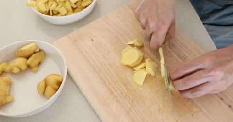 Cutting ginger into small pieces on cutting board Video stock 127897068