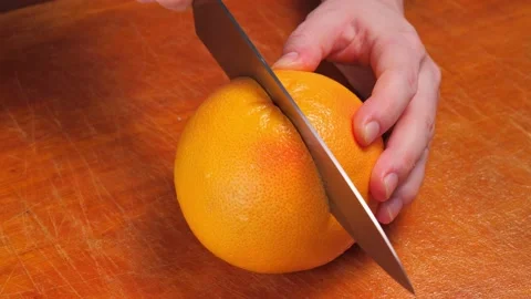 Cutting a grapefruit in two parts Stock Footage 146880288