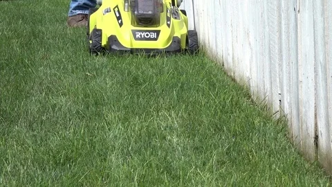 Cutting Grass with a battery powered lawn mower Stock Footage 78080841