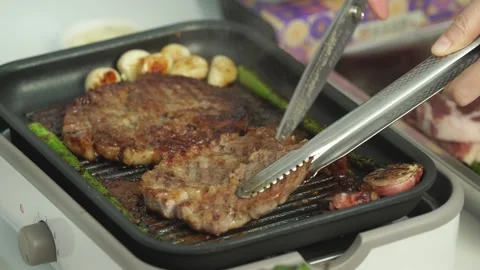 Cutting Grilled Pork Ribs with Scissors While Holding with Tongs Stock Footage 335736400