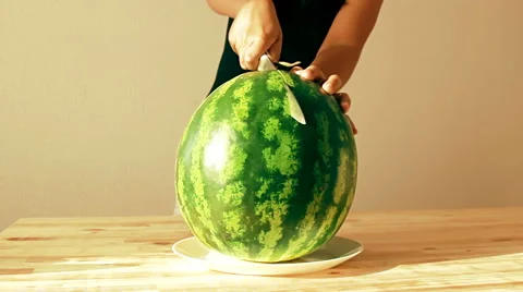 Cutting in half the big fresh and juicy watermelon on a wooden table in the s Stock Footage 65996667