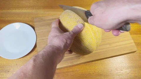 Cutting in half ripe yellow melon on a cutting board Stock Footage 320257047